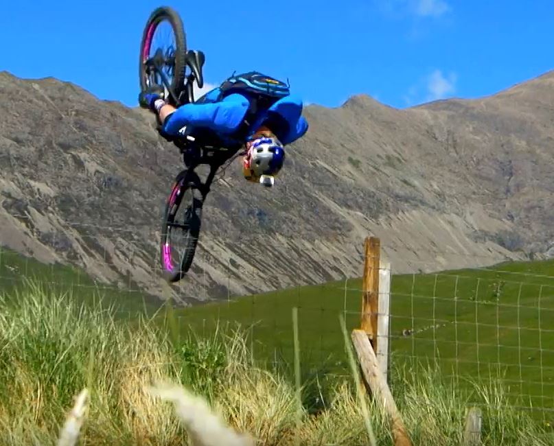 Danny MacAskill flipping over a fence.